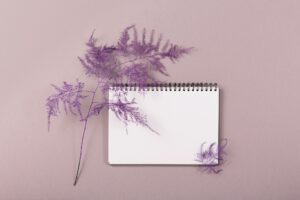 Blank diary, notepad mockup and dry plant on beige background
