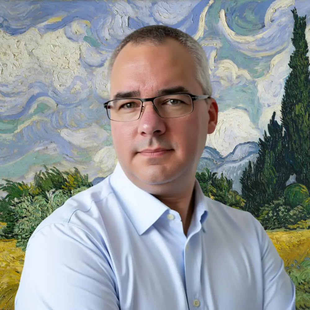 A man with short gray hair and glasses, wearing a light blue shirt, stands in front of a painted background resembling Van Gogh’s “Wheat Field with Cypresses.”. STG-Health