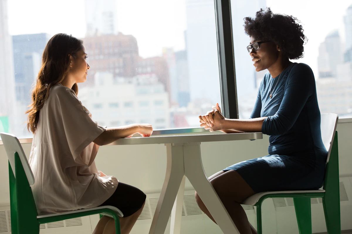 Two adults having a calm counselling conversation about treatment fit and next steps.